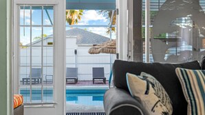 A living room with a view of a pool and outdoor seating.