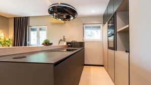 A modern kitchen with a central island, built-in appliances, and a large window providing natural light. - Beautiful home in Zadar (Zadar)