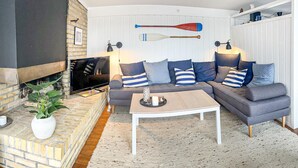 A living room with a fireplace, a television, a sofa set, and a coffee table. - Stunning home in Skånes Fagerhult (Skånes Fagerhult)