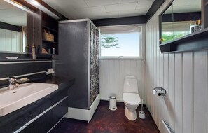 A compact bathroom with a sink, toilet, and window.