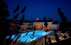 A modern house with a swimming pool, large glass doors, and a well-lit interior. - Amazing home in Krsan (Krsan)