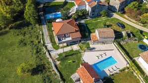 An aerial view of a residential area with houses, a swimming pool, and a tennis court. - Amazing home in Krsan (Krsan)