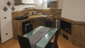 Una cucina compatta con zona pranzo, che include un'isola centrale, un forno integrato e un microonde.