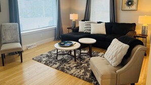 A living room with a sofa, armchair, coffee table, and two lamps.