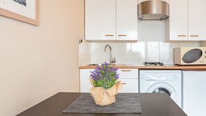 A kitchen with white cabinets, a stainless steel range hood, a microwave, and a washing machine. - Holiday Home 'Casa Karen' with Sea View, Private Terrace and Wi-Fi (Tossa del Mar)