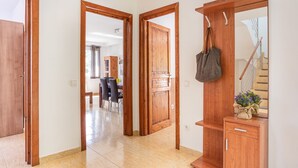 A hallway with wooden doors, a coat rack, and a staircase. - Holiday Home 'Casa Martini' with Sea View and Private Terrace (Tossa del Mar)