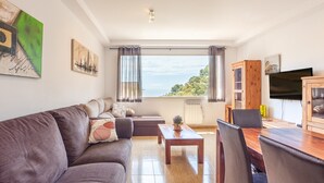A living room with a sofa, coffee table, and dining table with chairs. - Holiday Home 'Casa Martini' with Sea View and Private Terrace (Tossa del Mar)