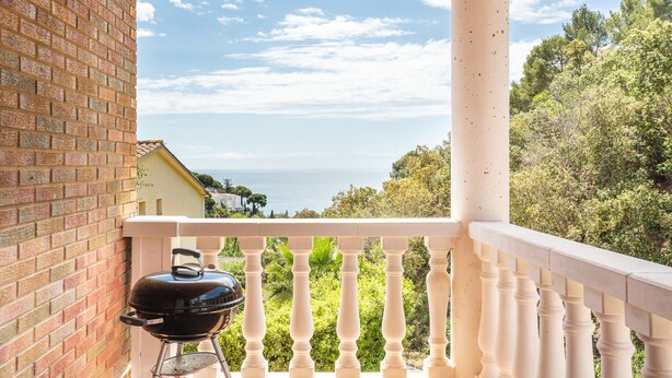 A balcony with a grill, a brick wall, and a view of the sea. - Holiday Home 'Casa Martini' with Sea View and Private Terrace (Tossa del Mar)