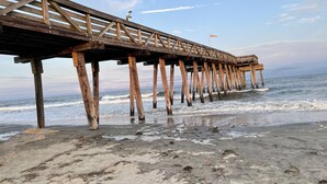 A wooden pier extending into the ocean with a flag on top. - Ocean City, NJ - Feet to the Boardwalk, New Listing, Turnkey & Clean! (Ocean City)