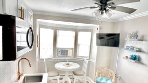 A compact kitchen with a sink, a round dining table, and a ceiling fan. - Ocean City, NJ - Feet to the Boardwalk, New Listing, Turnkey & Clean! (Ocean City)
