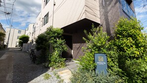 Un bâtiment moderne avec une façade en briques, une enseigne indiquant qu’il s’agit d’un hôtel, et un vélo garé à l’extérieur.