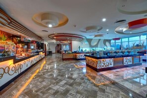 Welcome to our hotel lobby, featuring a central reception area with a decorative counter and a stylish ceiling design.