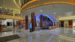 Eine geräumige Lobby mit gewölbter Decke, einer Treppe und einem Empfangsbereich.