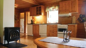 A wooden cabin interior with a kitchen area, including a stove, oven, and cabinets. - Amazing home in Sandeid with lake view (Sandeid)