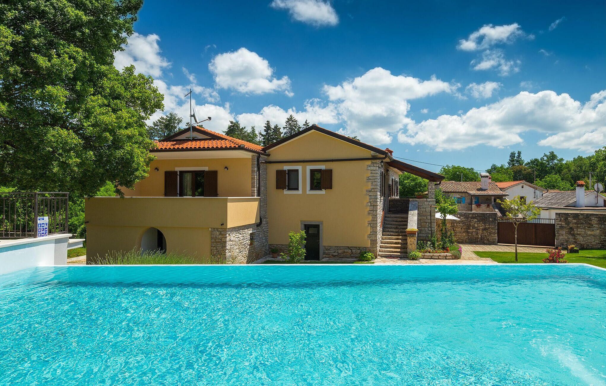 Une maison à deux étages avec une piscine à l’avant.