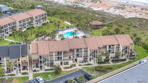 A multi-story hotel with a pool, balconies, and a beach view. - Beachfront Views from 2nd and 3rd Floor Balconies (St. Augustine Beach)