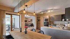 Une cuisine moderne dotée d’un îlot central, d’un four encastré et d’appareils électroménagers en acier inoxydable.