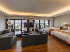 Una habitación de hotel moderna con una cama grande, un sofá, un televisor y vistas a la ciudad.