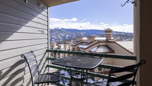 A balcony with a metal table and chairs, overlooking a snowy mountain landscape and buildings. - Eolus 626 - Managed by Purgatory Resort (Durango)