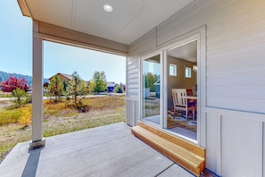 Enjoy a spacious porch with a welcoming entrance, leading to a living area with a dining table and chairs.