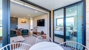 Et moderne interiør med spiseplads, opholdstue og balkon med seng.