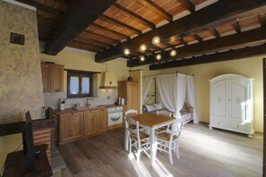 Una cocina rústica con armarios de madera, una mesa de comedor y una cama con dosel.