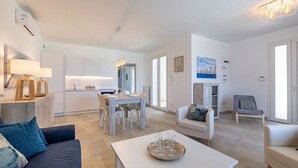 A modern living space with a kitchen, dining area, and seating area.