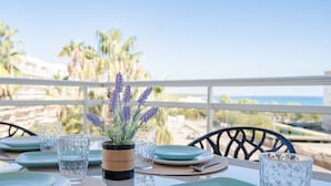 A table set for dining with plates, glasses, and a centerpiece of lavender. - Acogedor Apartamento con Piscina a un Minuto de la Playa (Miami Platja)