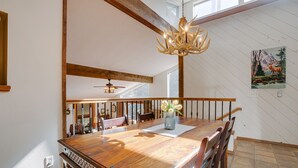 A dining area with a wooden table, chairs, a chandelier, and a painting on the wall. - Home near Monte Verde Lake with forest views (Angel Fire)