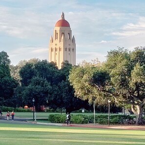 Un grand bâtiment doté d’un dôme rouge et de plusieurs tours, entouré d’arbres et d’une zone herbeuse.