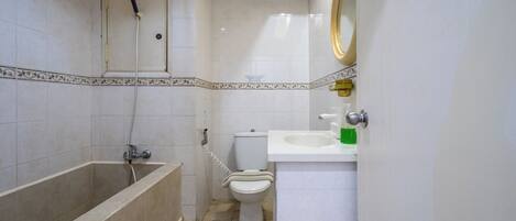 Un baño con bañera, inodoro y lavamanos.