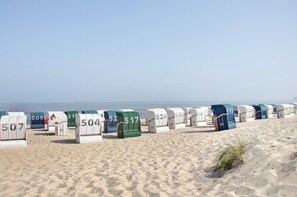 Cabanes de plage numérotées de 507 à 538, situées sur une plage de sable, avec la mer en arrière-plan.