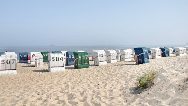 Beach huts numbered 507 to 538 on a sandy beach with the sea in the background.