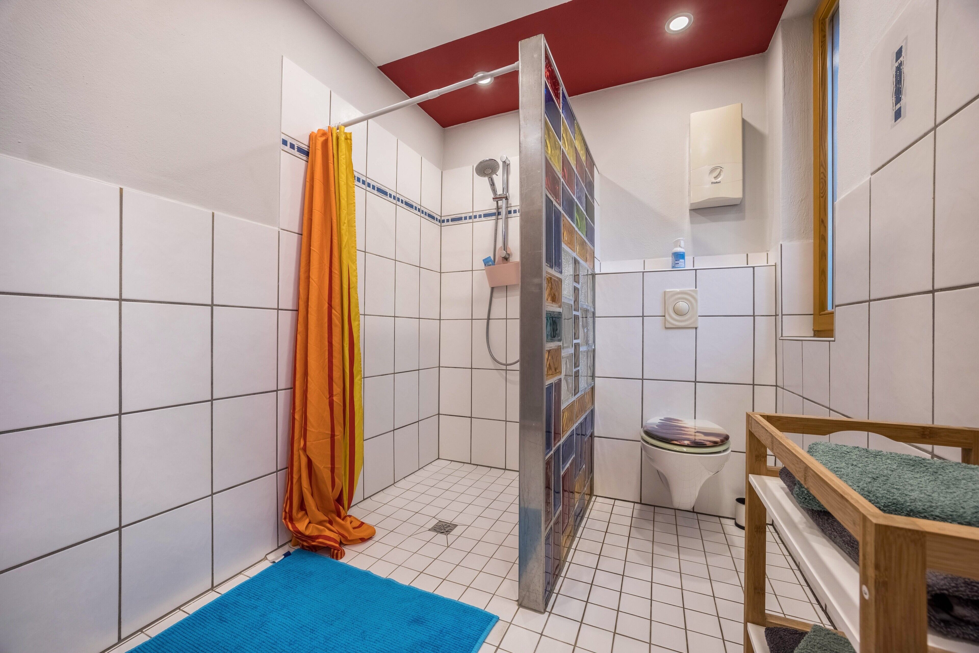Une salle de bain avec une douche, des toilettes et un banc en bois.