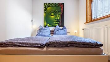 Ein Bett mit Kopfteil, Kissen und einem Wandbild.