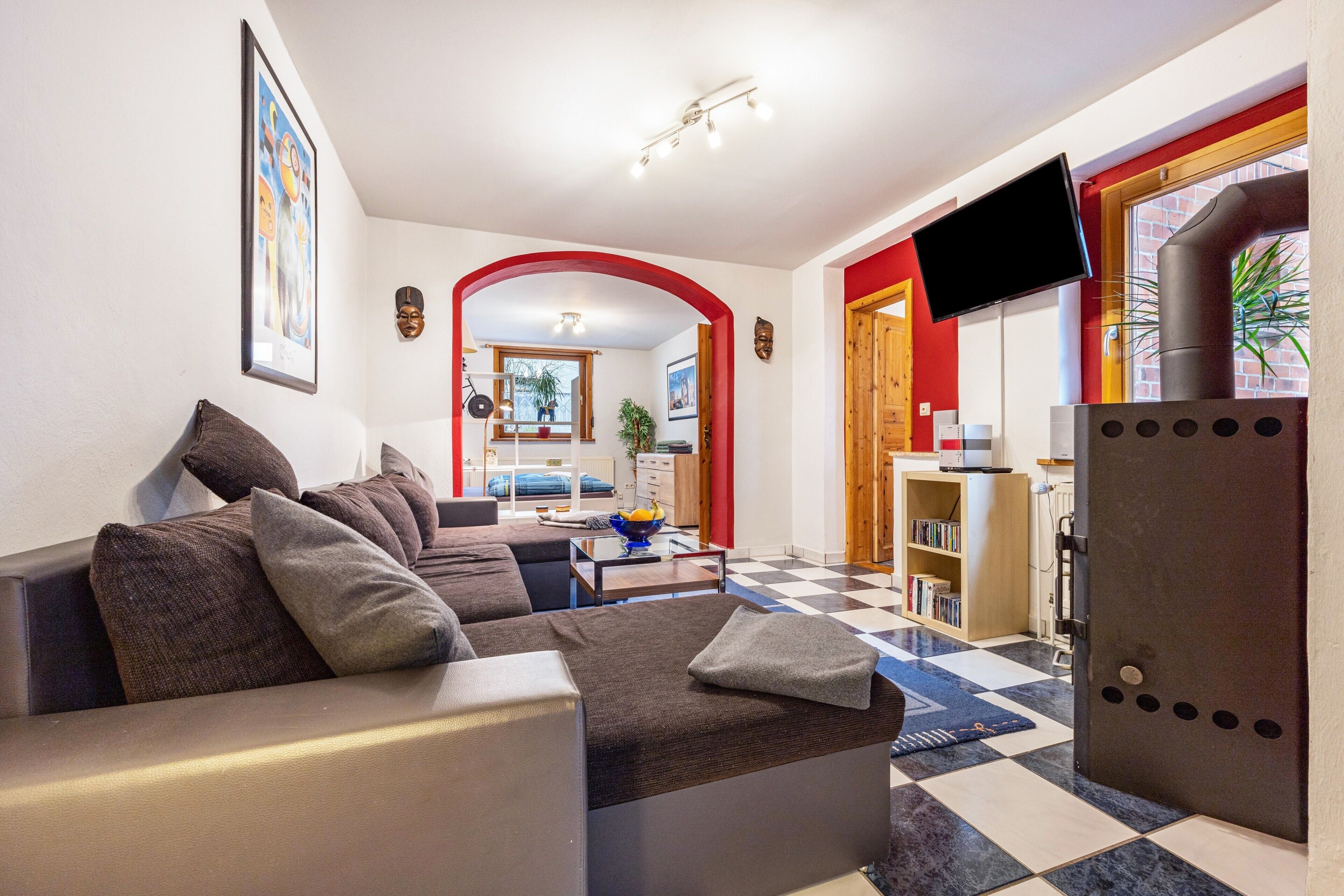 Ein Wohnzimmer mit einer Couch, einem Couchtisch und einem an der Wand befestigten Fernseher.