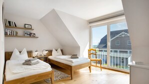 A modern bedroom with two beds, a large window, and a balcony. - Holiday Home 'Schilfblick' with Lake View, Private Terrace and Wi-Fi (Wieck a Darß)