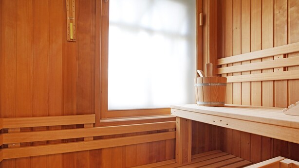 A wooden sauna with benches and a window. - Holiday Home 'Schilfblick' with Lake View, Private Terrace and Wi-Fi (Wieck a Darß)