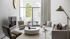 A modern living room with a sofa, armchair, coffee table, and a television. - Future Space in the heart of Darlinghurst (Darlinghurst)