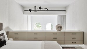 A modern bedroom with a large bed, a dresser with multiple drawers, a lamp, and a decorative globe. - Future Space in the heart of Darlinghurst (Darlinghurst)
