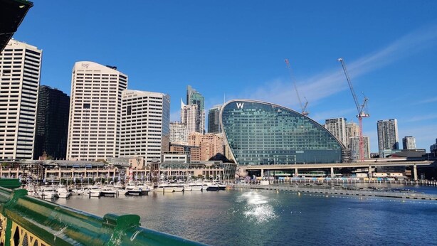 A waterfront cityscape with modern high-rise buildings, including a distinctive curved glass building with a 'W' logo. - Future Space in the heart of Darlinghurst (Darlinghurst)
