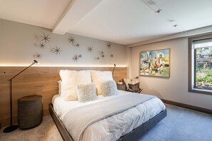 A modern bedroom with a bed, star wall decor, a painting, and a window.