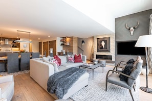 A modern living room with a sofa, coffee table, and fireplace.