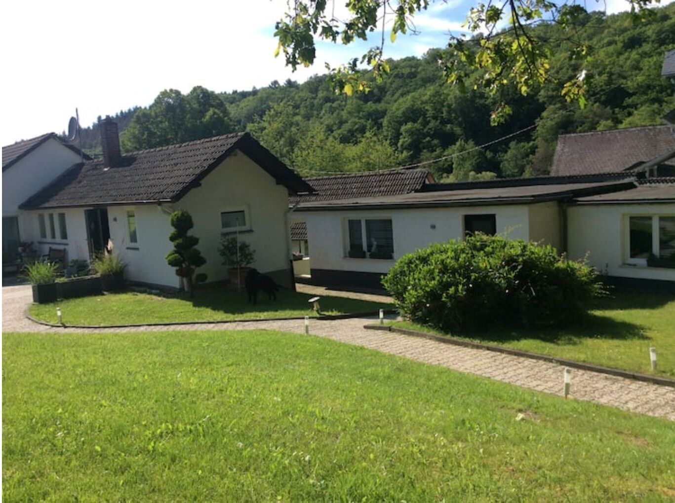 Une maison à deux étages avec une pelouse bien entretenue et une allée pavée.