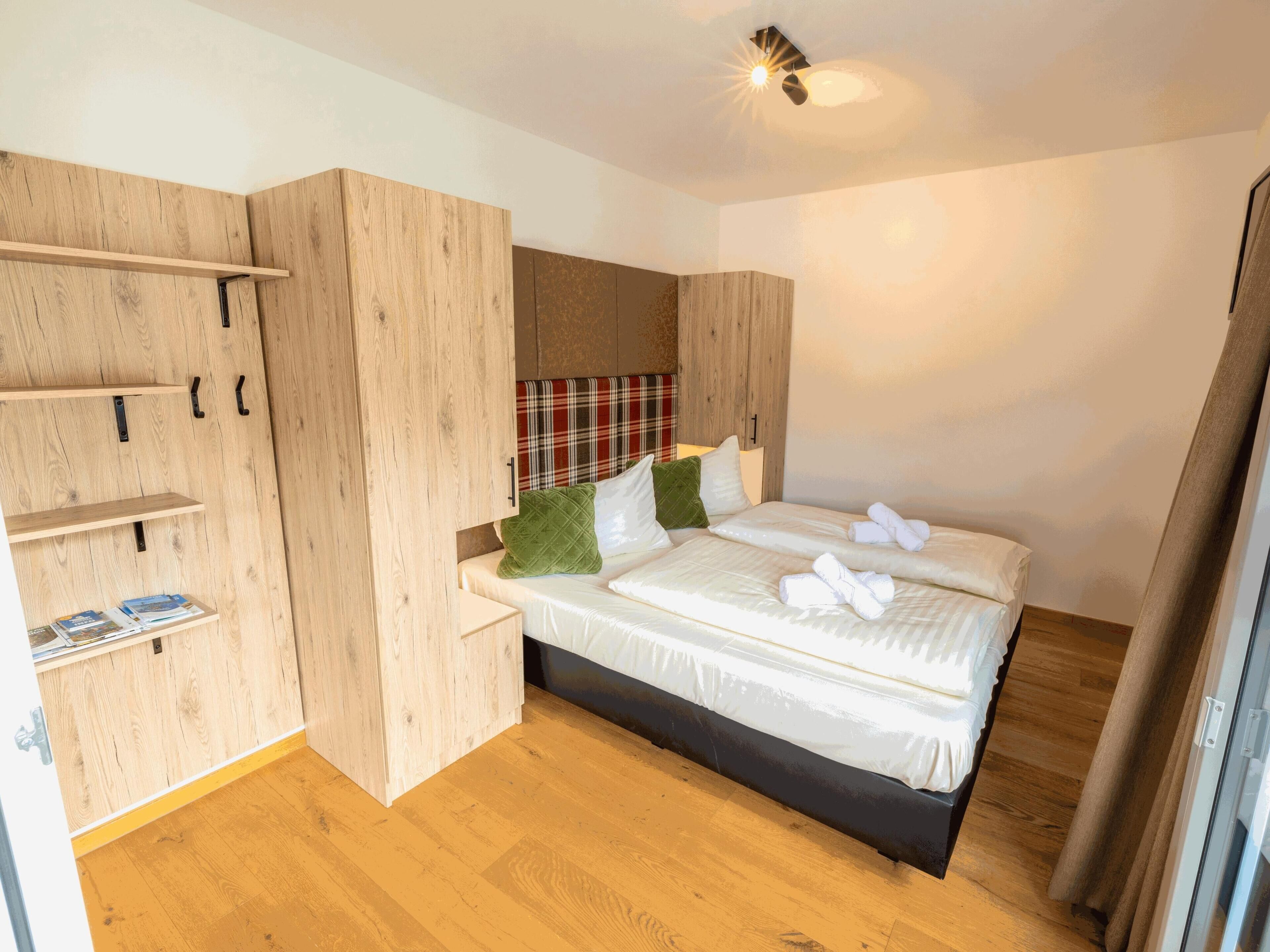 Una camera da letto con un letto, un'armadio in legno e una scaffalatura.