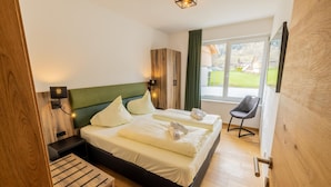 Una habitación de hotel moderna con una cama de madera, un escritorio pequeño y una silla.