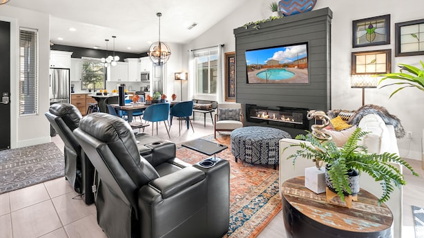 A modern living room with a fireplace, leather sofa, and a dining area. - Red Mountain Villa, Game Room, Community Pool, Smart Tv's (Washington)