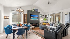A modern living room with a fireplace, a flat-screen TV, blue chairs, and a black leather sofa. - Red Mountain Villa, Game Room, Community Pool, Smart Tv's (Washington)