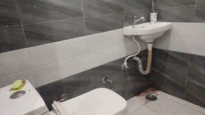 A bathroom with a toilet, sink, and shower. - VS Residency (Mathura)