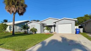 A residential house with a front yard, a palm tree, and a garage.